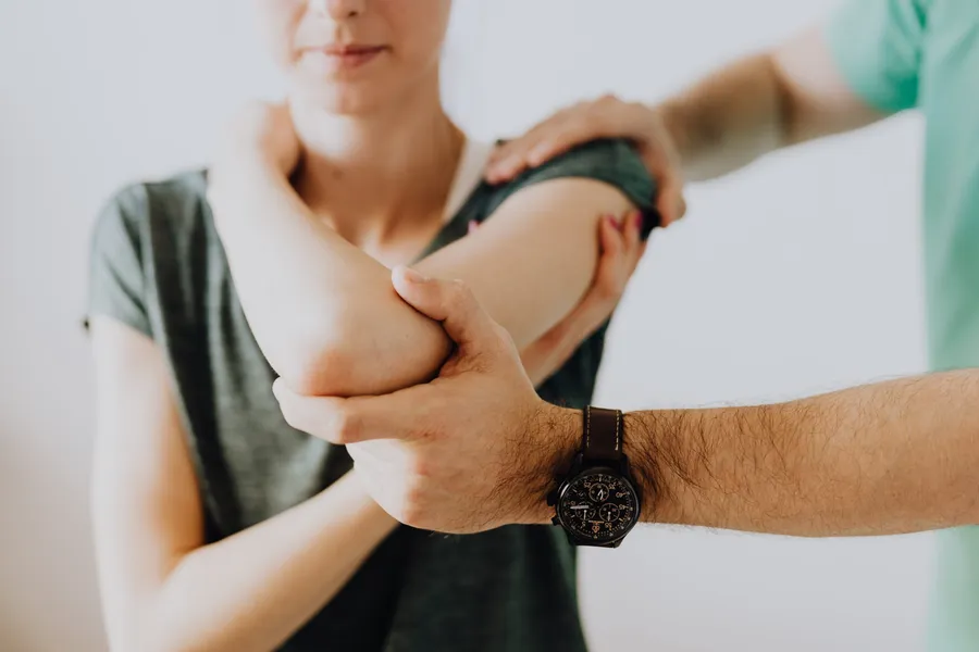 Chiropractor working on a patient's arm and shoulder