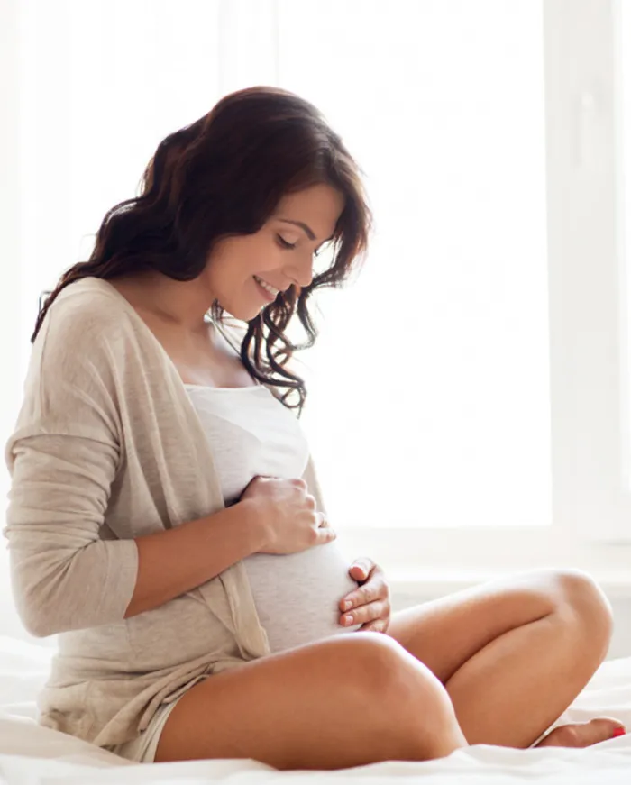 Expecting mother resting her hands on her belly