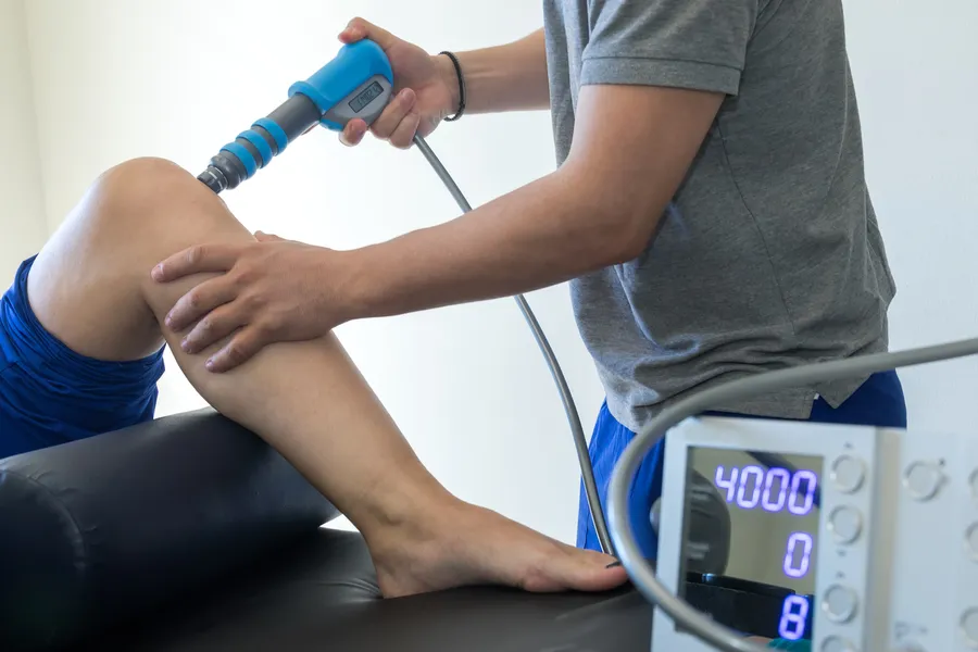 Shockwave therapy device being applied to a patient's knee