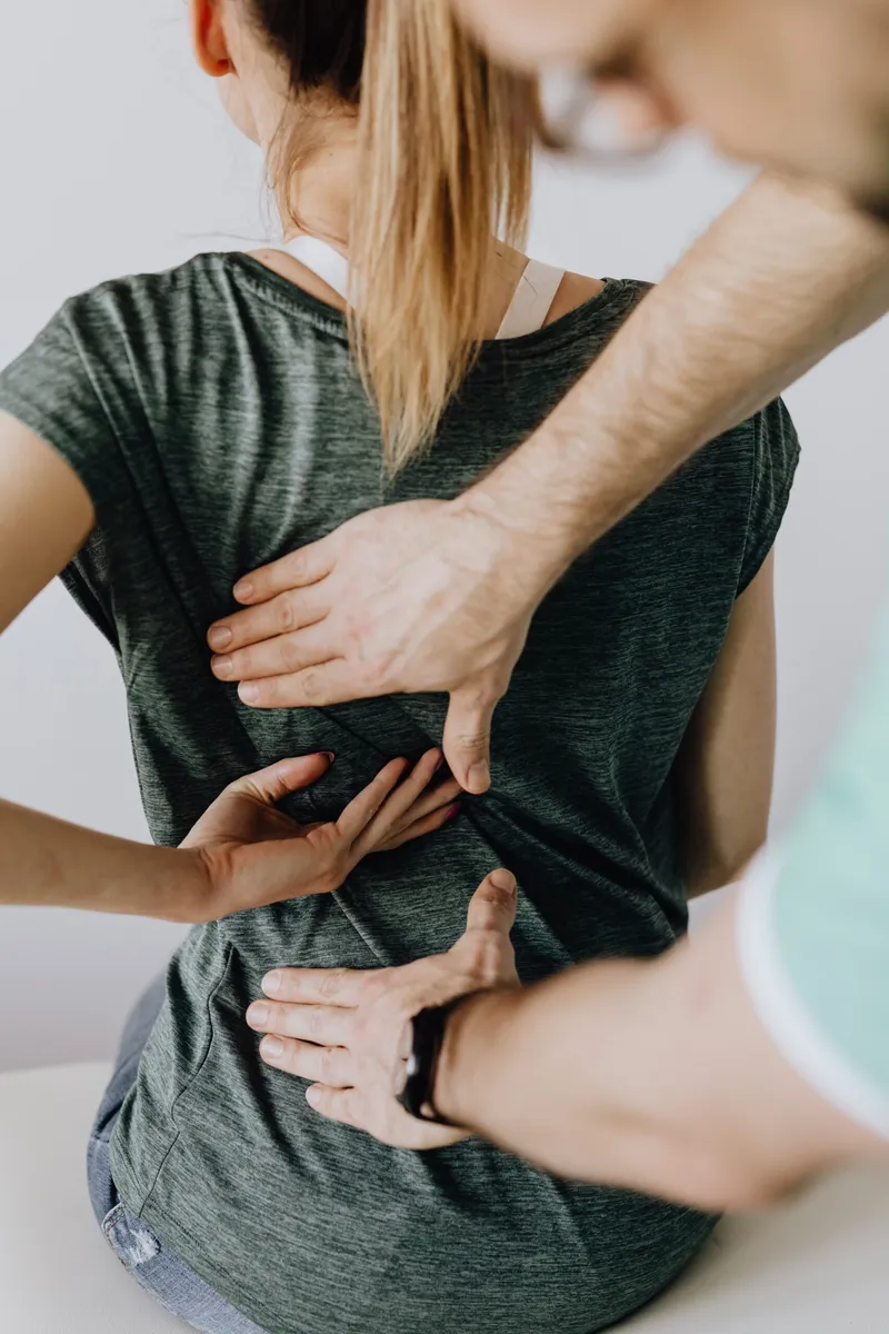 Chiropractor examining a patient's lower back